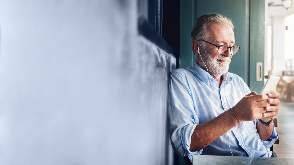 Elderly man watching online movie from his phone
