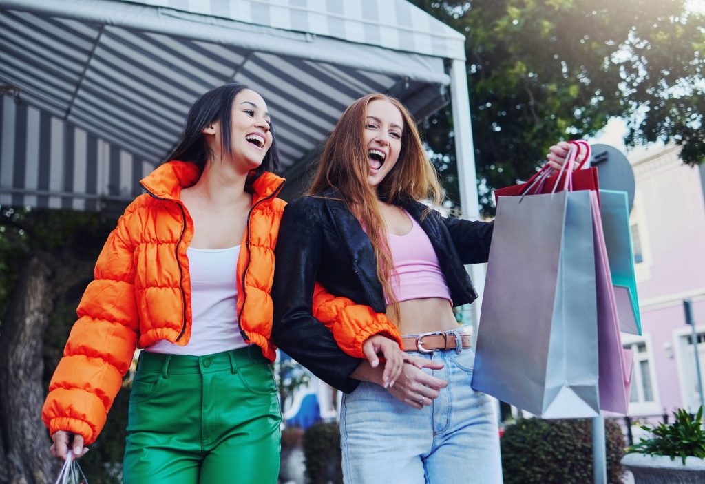 Excited gen Z shoppers with shopping bags